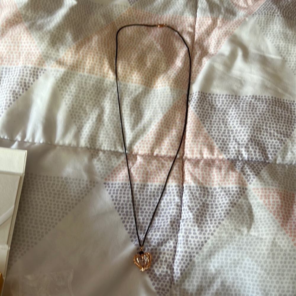 Rose gold tone crown with black necklace